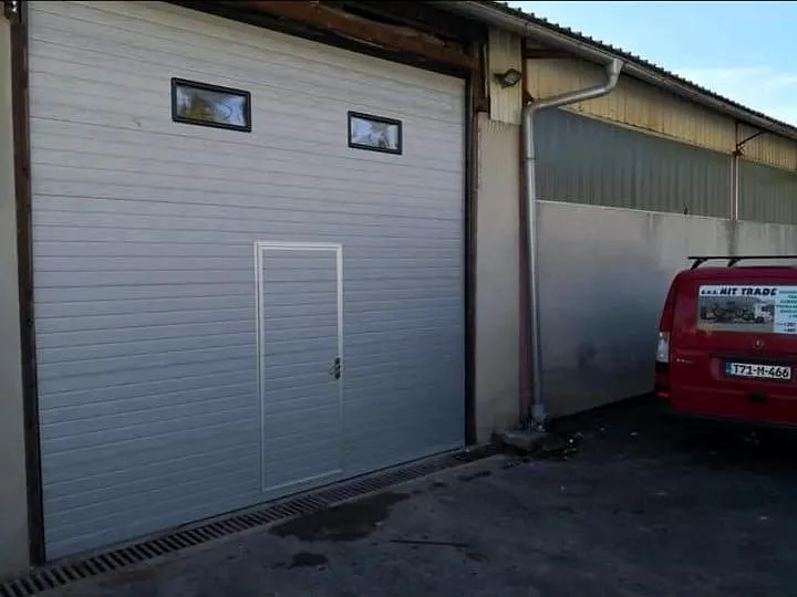 Siva sekcijska garažna vrata s steklenimi okenci