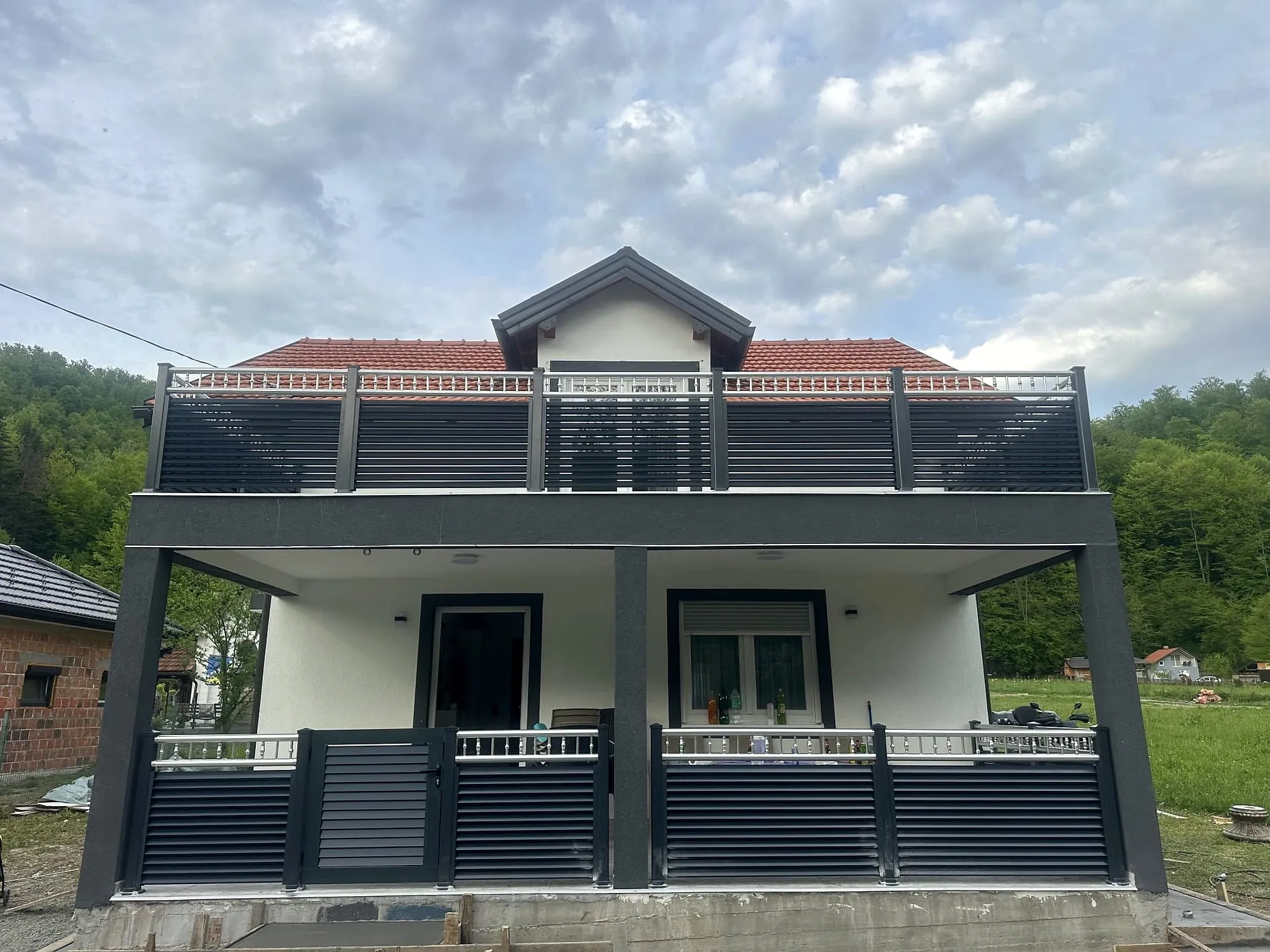 Hausfront mit Alu-Geländer an Balkon und Terrasse