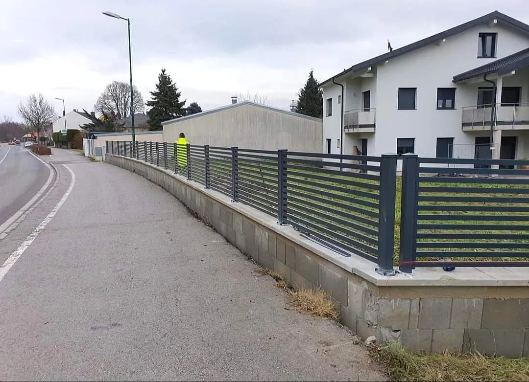 Langer Alu-Zaun mit Abstand entlang der Straße