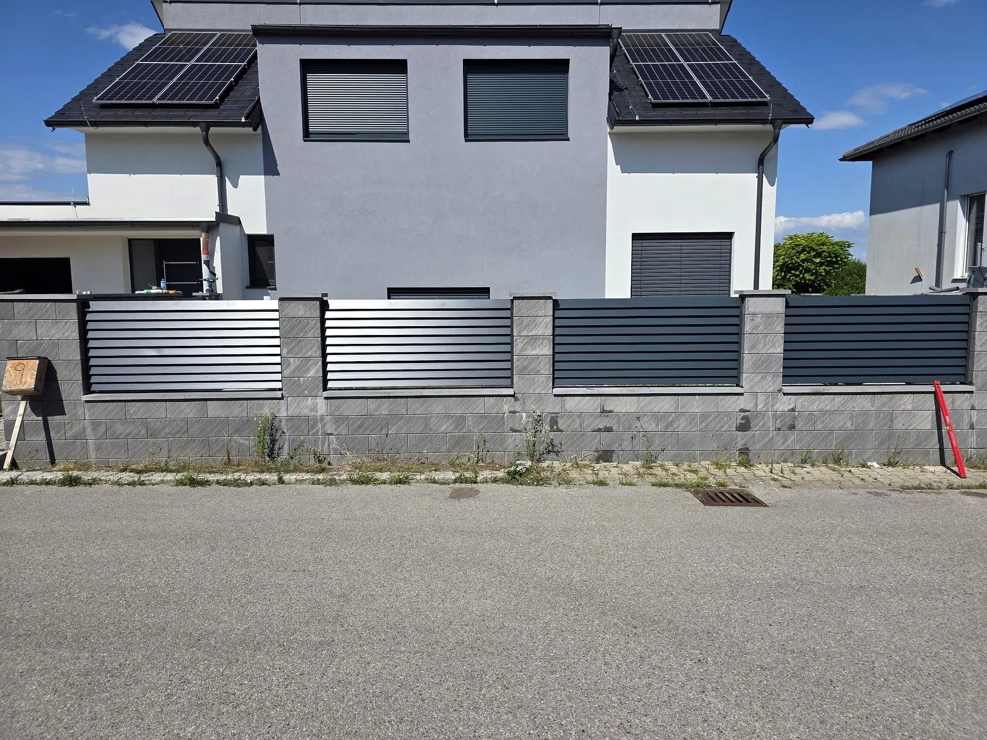 Aluminiumzaun rund ums Haus auf Sockelmauer