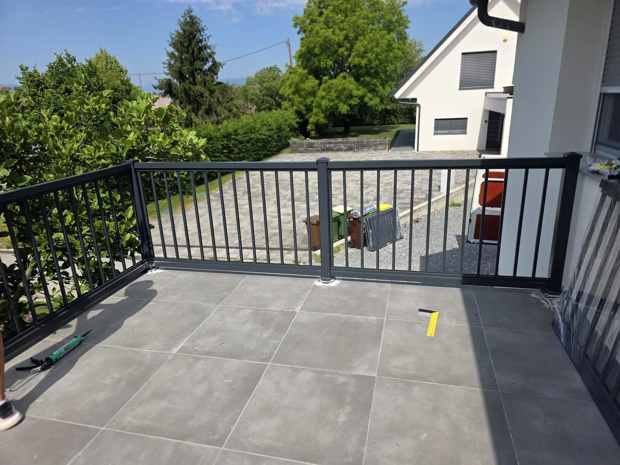Anthrazitfarbenes Stab-Terrassengeländer auf einer gefliesten Terrasse